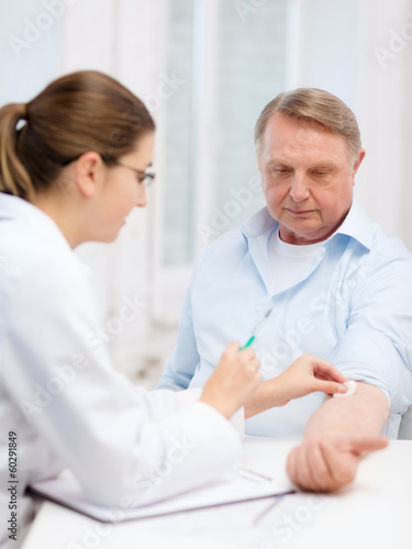 female doctor doing injection to old man