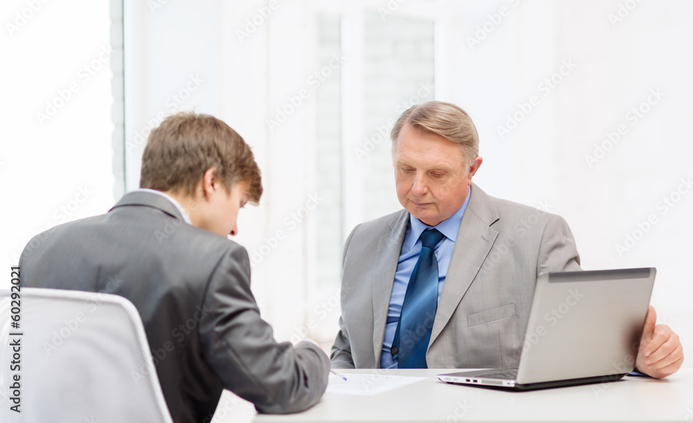 Fototapeta premium older man and young man signing papers in office