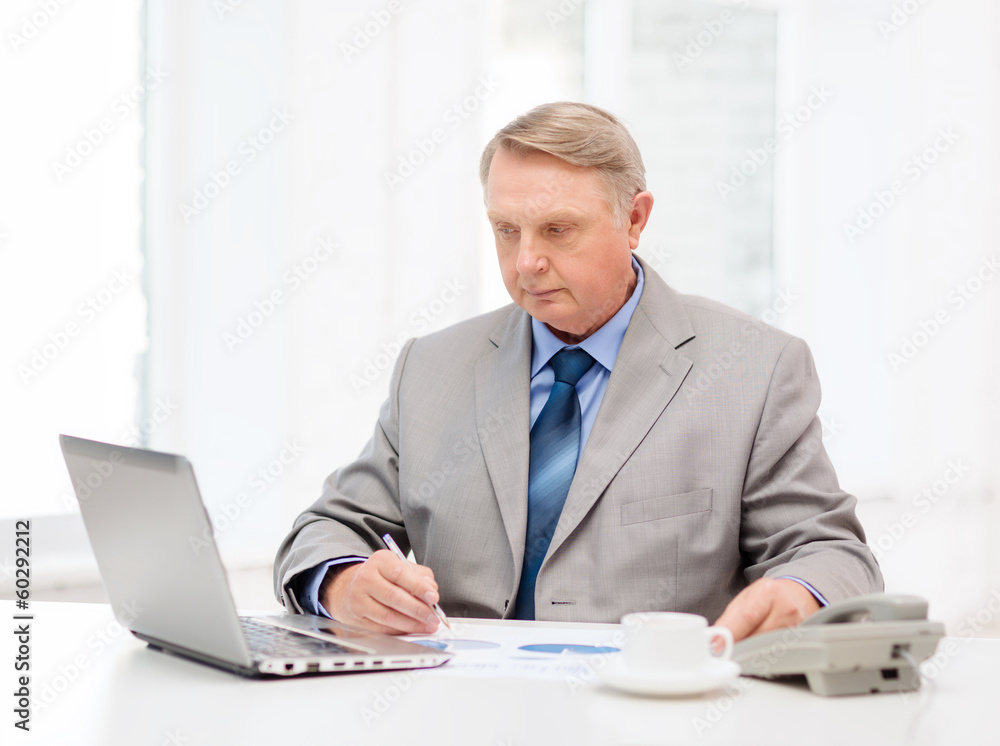 busy older businessman with laptop and telephone busy older businessman with laptop and telephone