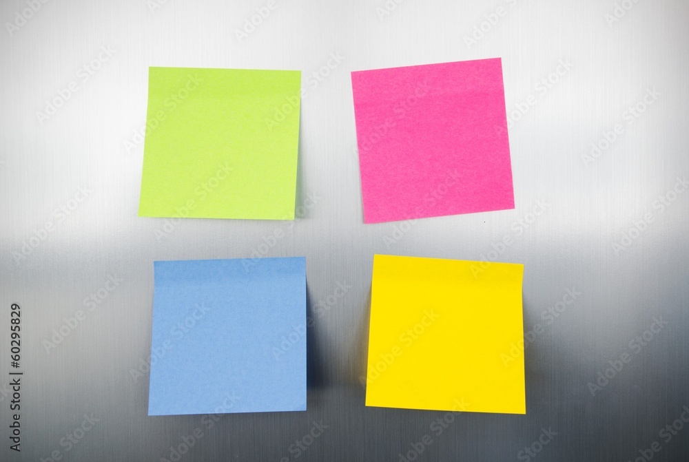 Close up of coloured reminders on fridge. Metallic background wi Close up of coloured reminders on fridge. Metallic background wi