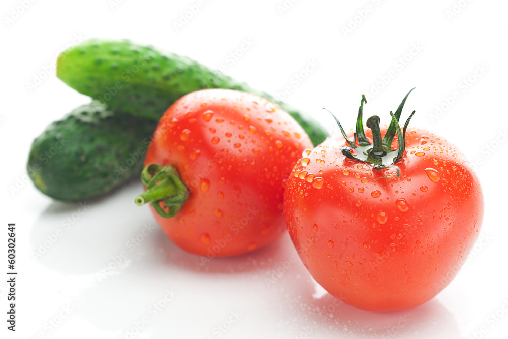 tomato with water drops and cucumbers isolated on white tomato with water drops and cucumbers isolated on white