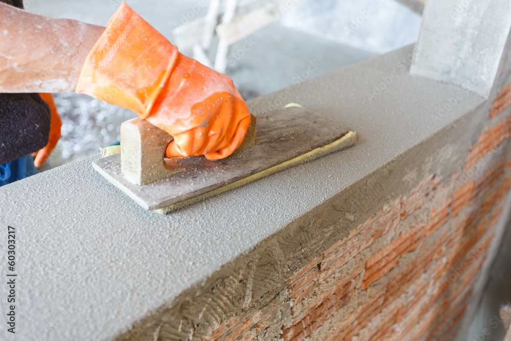 plasterer concrete worker at wall of house construction