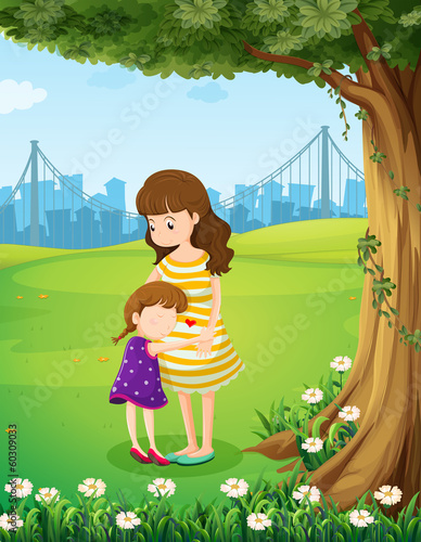 A mother and her daughter under the tree