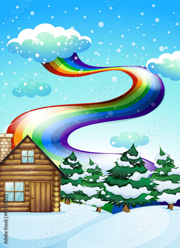 A wooden house near the pine trees with a rainbow uphigh