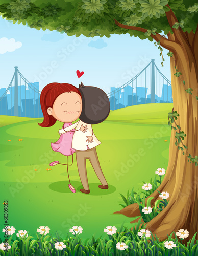 A couple hugging each other near the tree