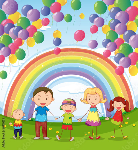 A happy family under the floating balloons with a rainbow