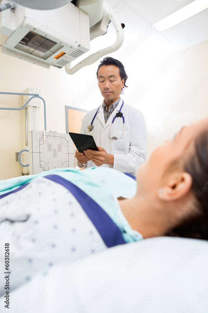 Radiologist Using Digital Tablet In Examination Room Radiologist Using Digital Tablet In Examination Room