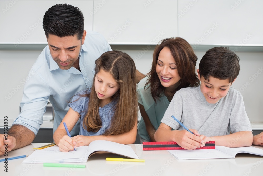Fototapeta premium Couple helping kids with their homework in kitchen
