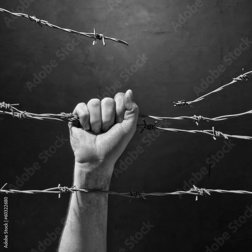 hand behind barbed wire