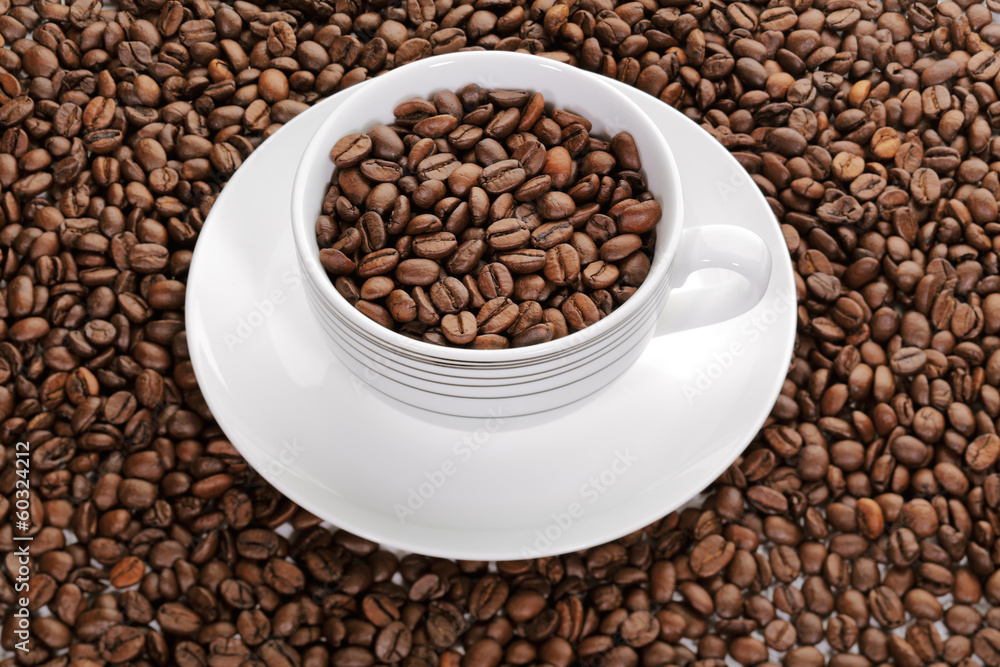 A cup full of coffee beans surrounded by more coffee beans A cup full of coffee beans surrounded by more coffee beans