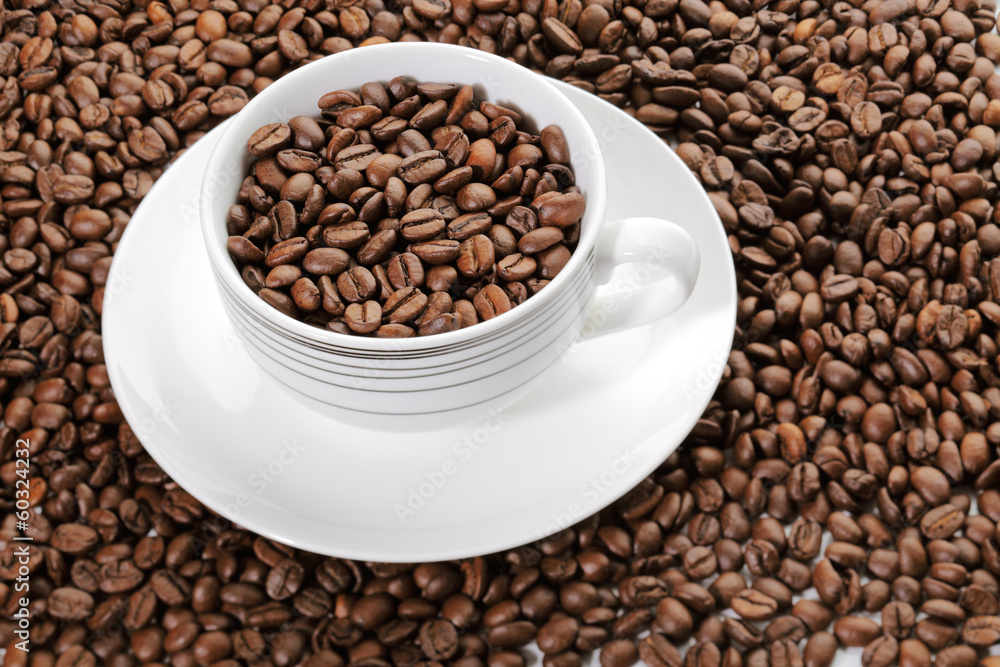 A cup full of coffee beans surrounded by more coffee beans A cup full of coffee beans surrounded by more coffee beans