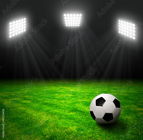 Soccer ball in grass, soccer stadium with the dright lights. © vencav