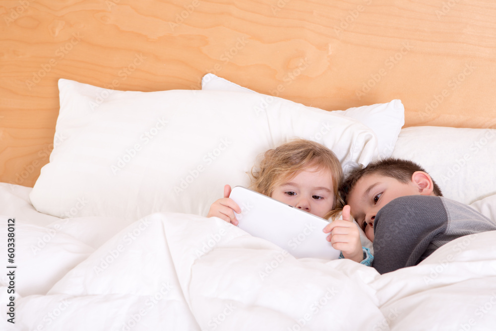 Little brother and sister snuggling up at bedtime Little brother and sister snuggling up at bedtime