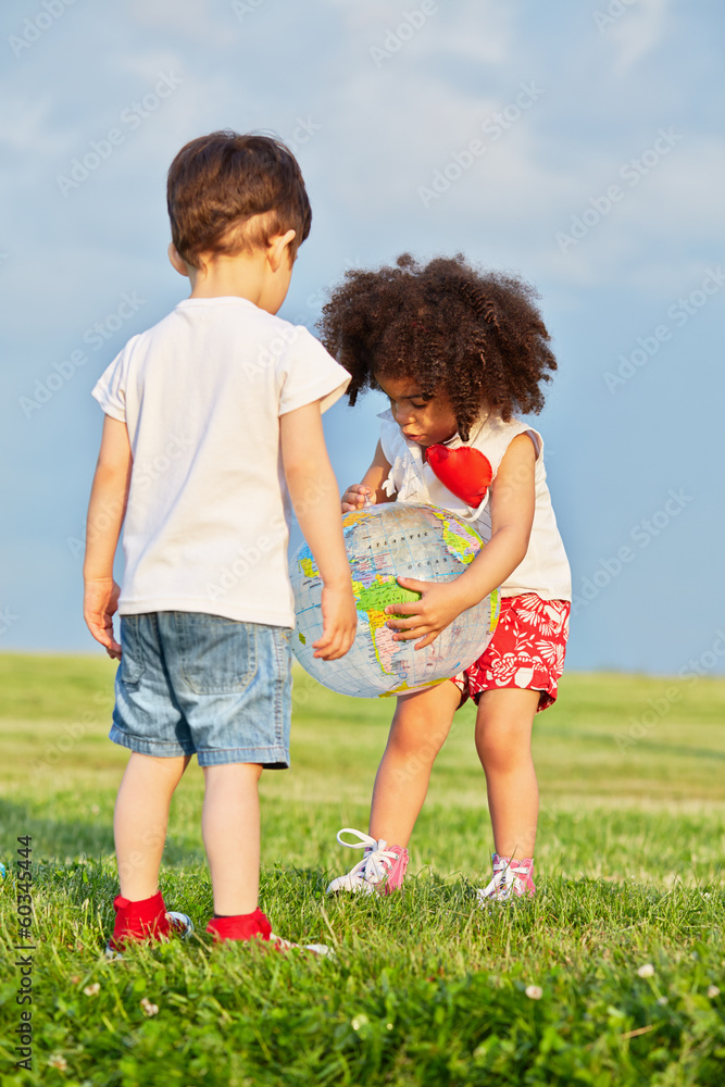 Fototapeta premium Little boy and little girl play with inflatable ball-globe