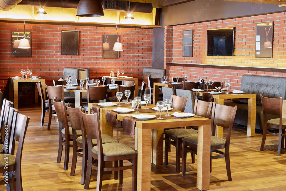 Restaurant room with wooden furniture and walls of red bricks