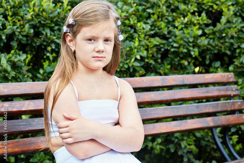 Little girl sits on bench in summer park Little girl sits on bench in summer park