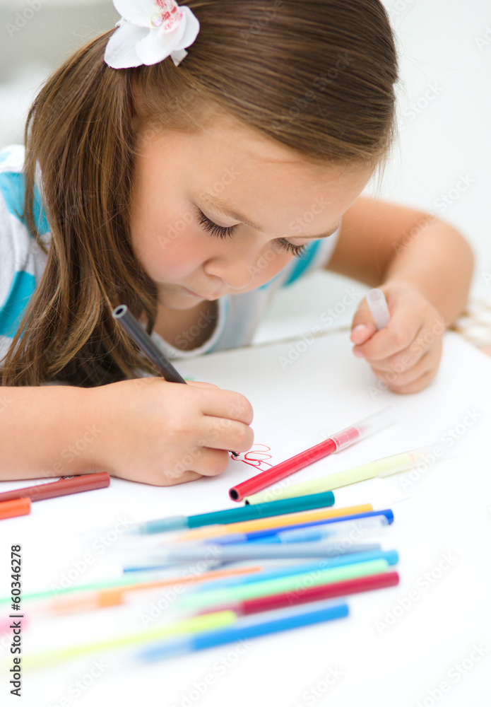 Little girl is writing using a pen Little girl is writing using a pen