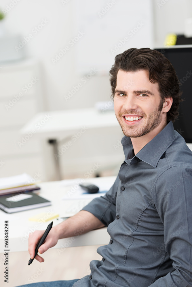 junger mann am arbeitsplatz im büro