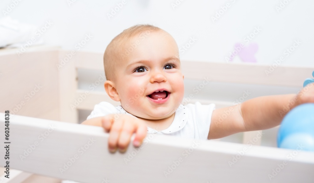 Close-up of a cheerful cute baby in the crib Close-up of a cheerful cute baby in the crib