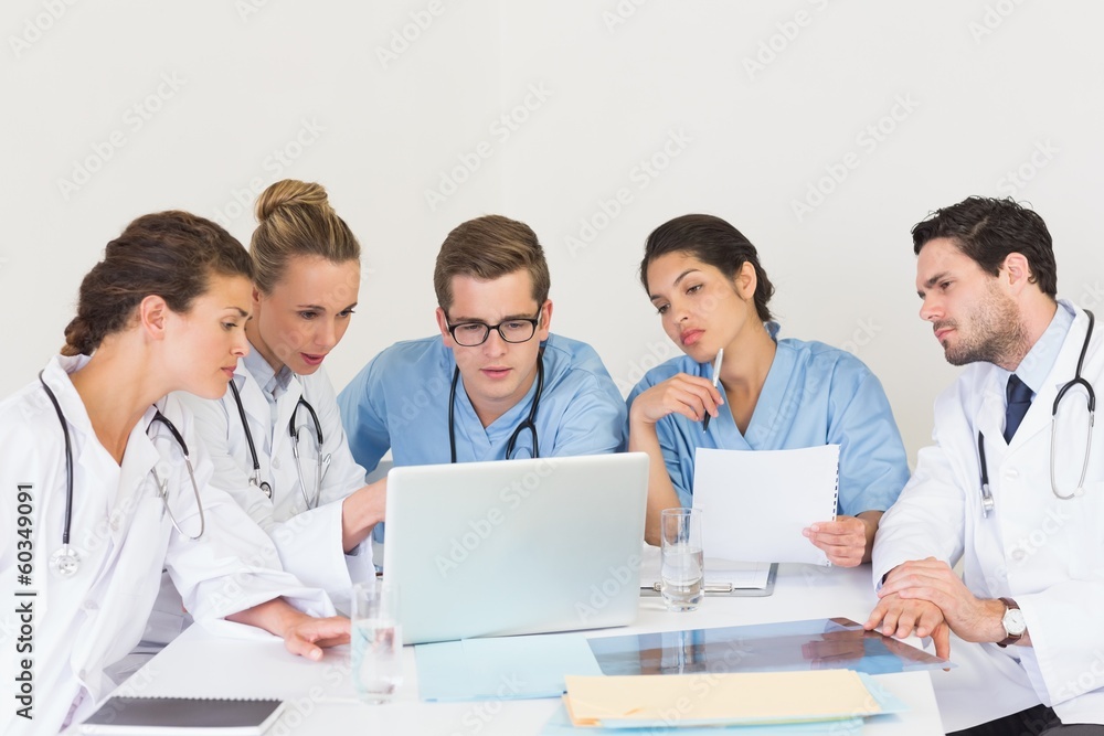 Doctors and nurses discussing over laptop Doctors and nurses discussing over laptop