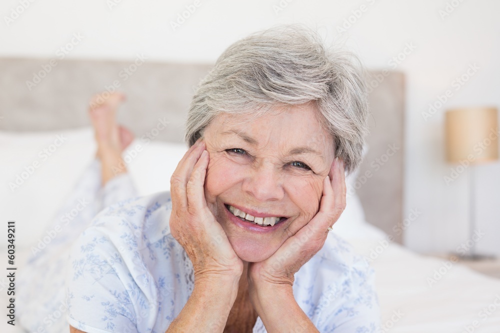 Senior woman with head in hands on bed Senior woman with head in hands on bed