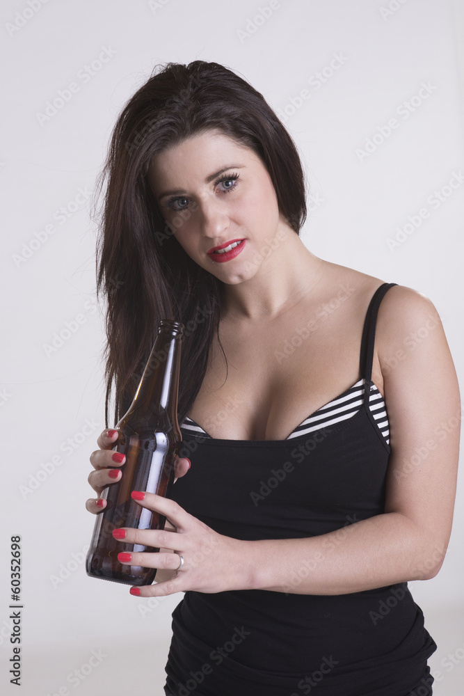 Young woman drinking from a brown beer bottle Young woman drinking from a brown beer bottle