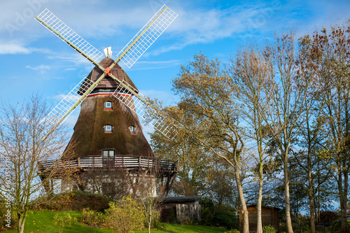 traditionelle alte windmühle in der grünen landschaft an der o photo