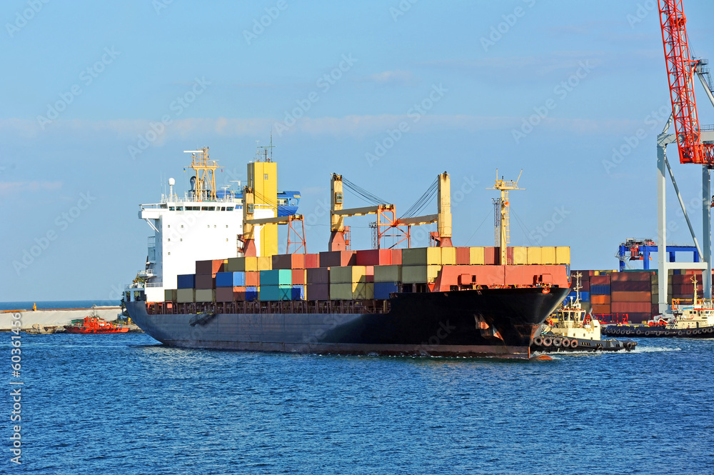 Tugboat assisting container cargo ship to harbor quayside Tugboat assisting container cargo ship to harbor quayside