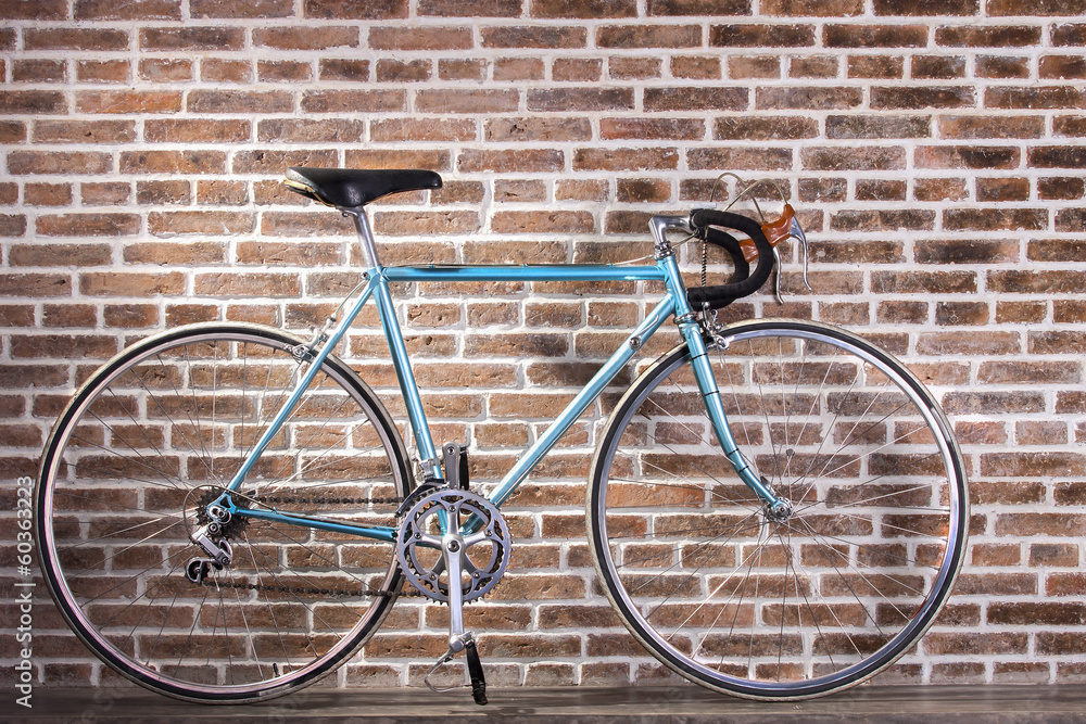 Blue retro bicycle on red brick wall background