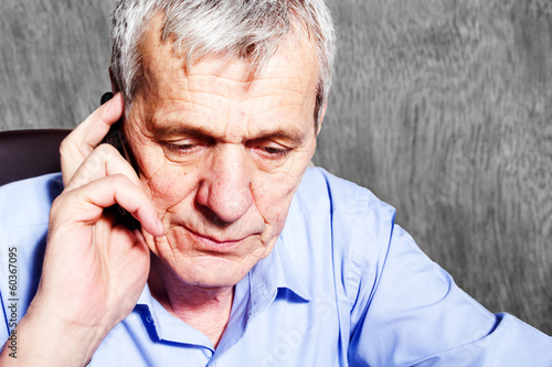 Elderly worried businessman with mobile phone