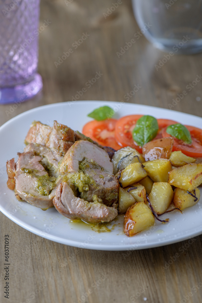 Stuffed pork fillet with tomatoes and basil on the side on an ol Stuffed pork fillet with tomatoes and basil on the side on an ol