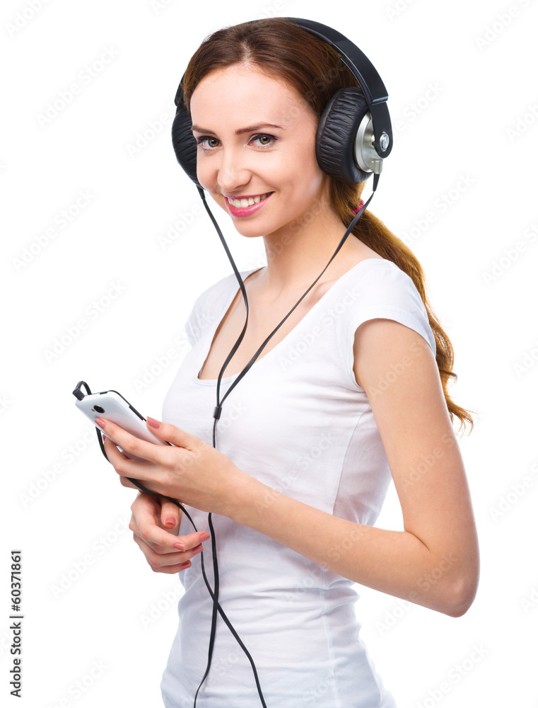 Young woman enjoying music using headphones Young woman enjoying music using headphones