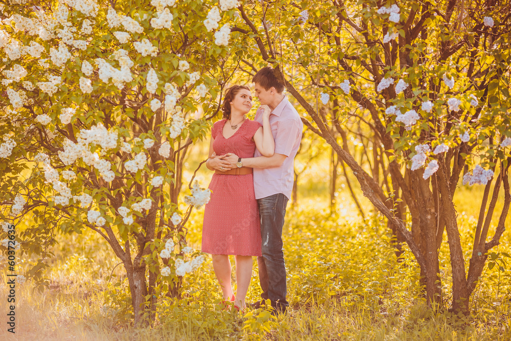 Portrait of young couple in flowering park Portrait of young couple in flowering park