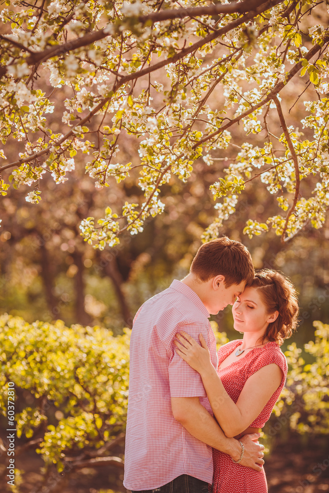 Portrait of young couple in flowering park