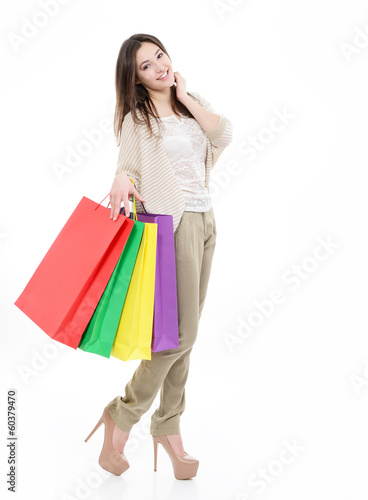 beautiful happy young woman with colored shopping bags, full len