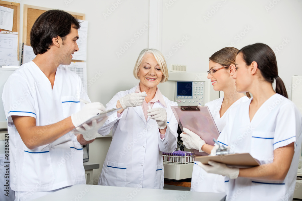 Scientists Discussing Over Sample In Laboratory Scientists Discussing Over Sample In Laboratory