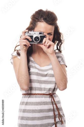 Brunette young woman taking photo by retro camera