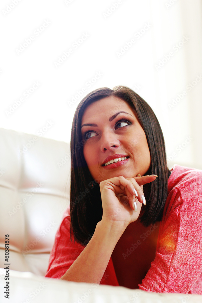 happy woman lying on the sofa and looking away happy woman lying on the sofa and looking away