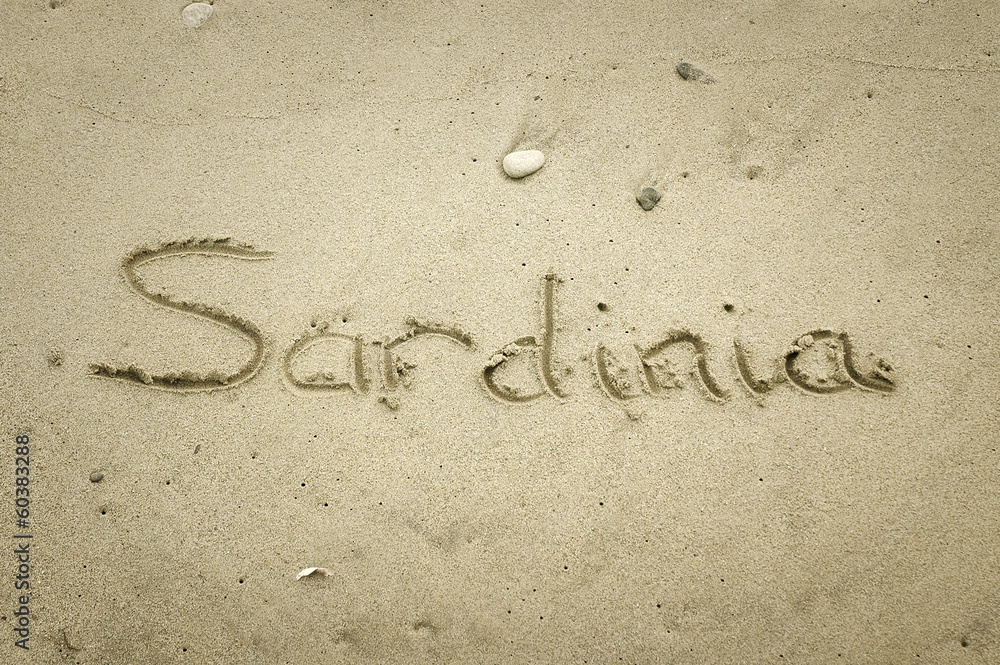 Fototapeta premium Sardinia - written in sand on beach texture