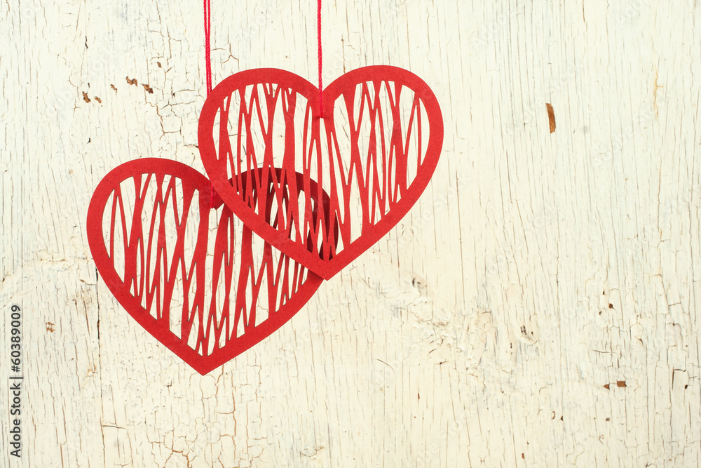 Two paper hearts on a  old  white wood