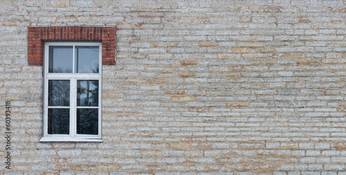 Limestone wall with a window in the winter as a background