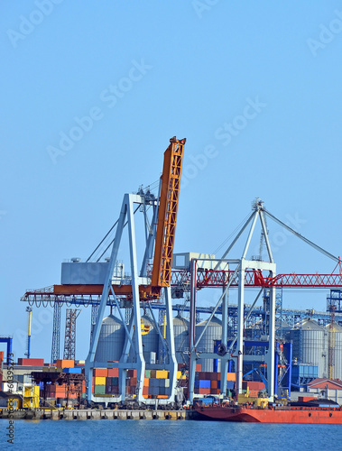 Port cargo crane and container over blue sea background