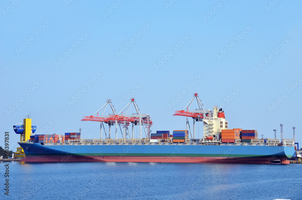 Fototapeta premium Container stack and ship under crane bridge