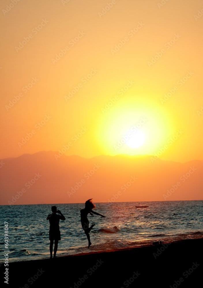 Couple having fun on beach at sunset