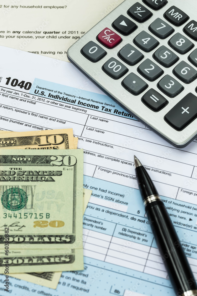 Tax form with pen, calculator, and dollar banknote taxation conc Tax form with pen, calculator, and dollar banknote taxation conc