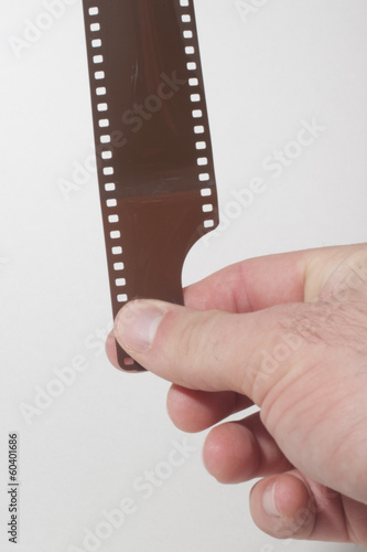A hand pulling a 35mm film strip.