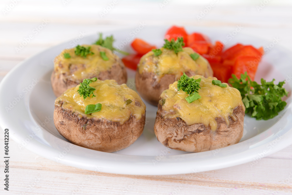 Stuffed mushrooms on plate on table on light background Stuffed mushrooms on plate on table on light background