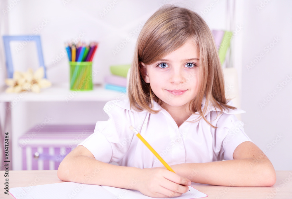 Little girl sitting at desk in room Little girl sitting at desk in room
