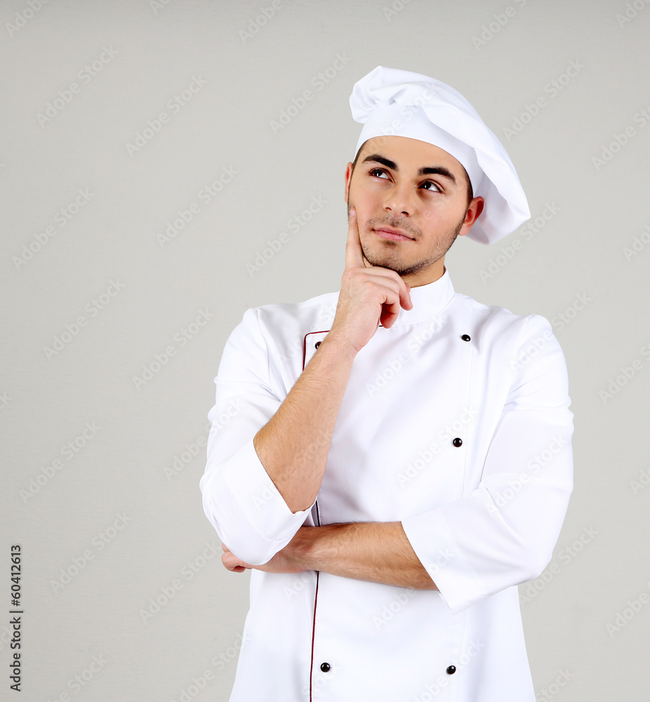 Professional chef in white uniform and hat, on gray background Professional chef in white uniform and hat, on gray background