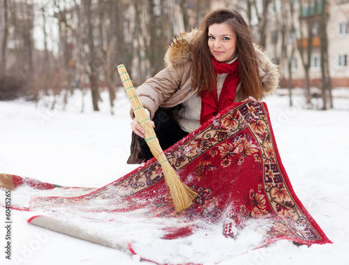 woman cleans carpet with snow photo